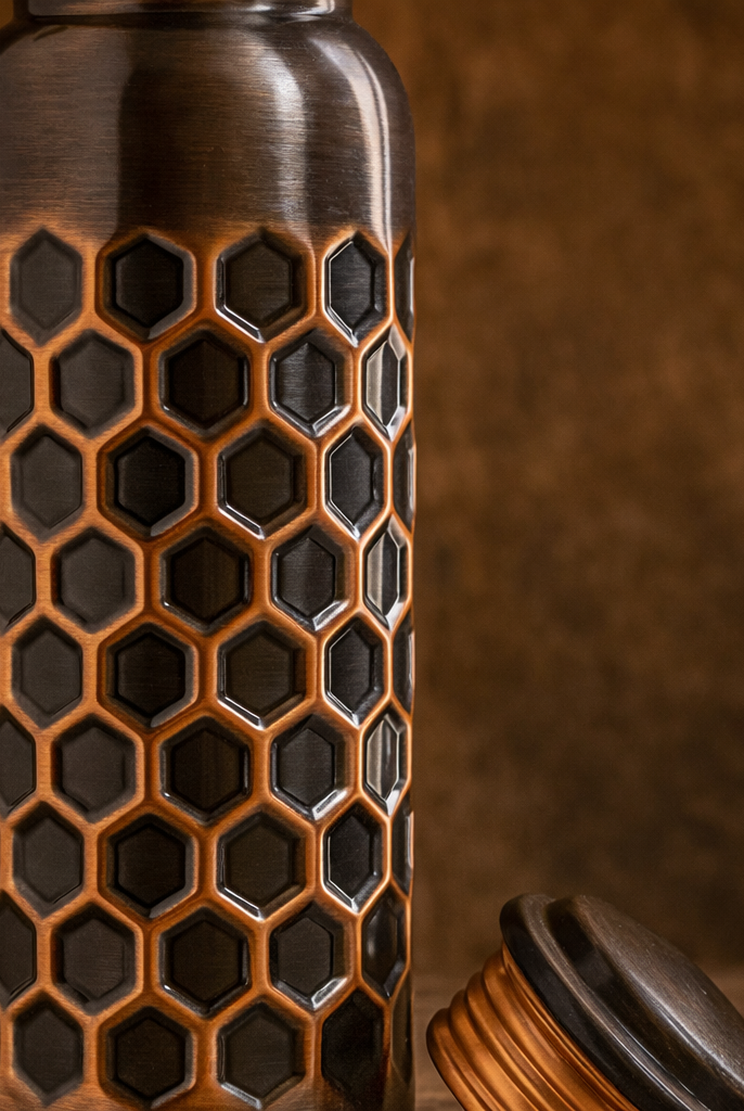 950ml antique embossed copper water bottle placed in a garden setting.