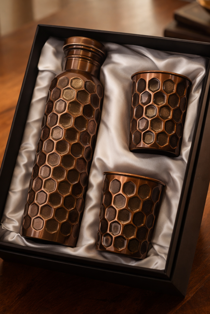 Antique finish copper bottle and glass set displayed on a table