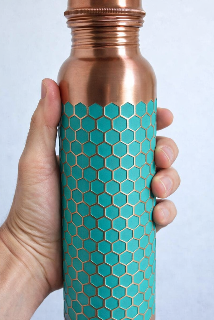 Close-up of a 950ml pure copper bottle with an intricate green embossed design