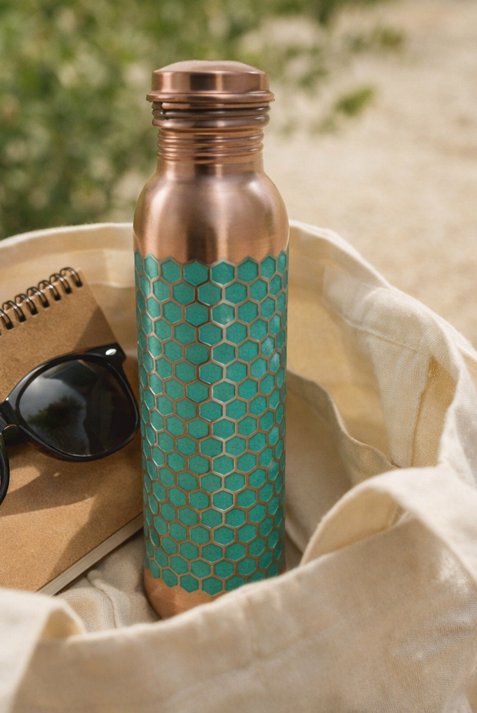 Stylish green embossed copper bottle placed in an outdoor garden setting