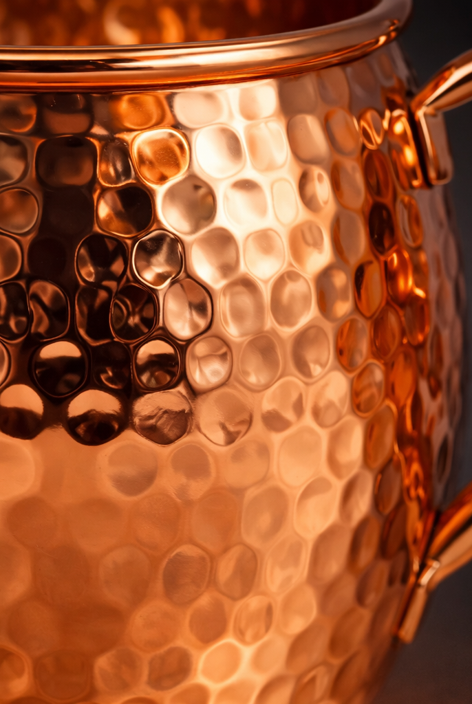 Shiny polished copper mug featuring a hand-hammered texture.