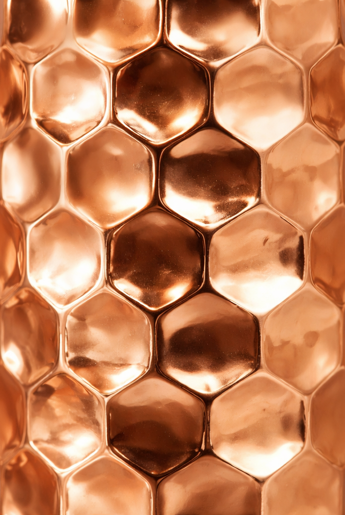 Reflective shiny copper water bottle featuring detailed embossed patterns.