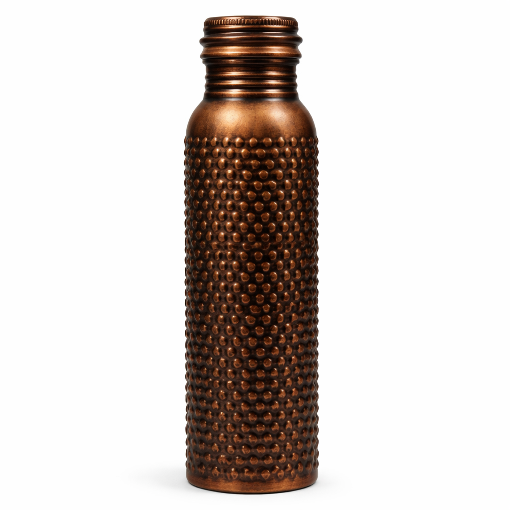 Detailed close-up of the intricate floral embossed patterns on an antique copper bottle.