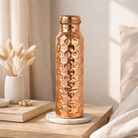 Elegant shiny polish copper bottle with a decorative textured surface.