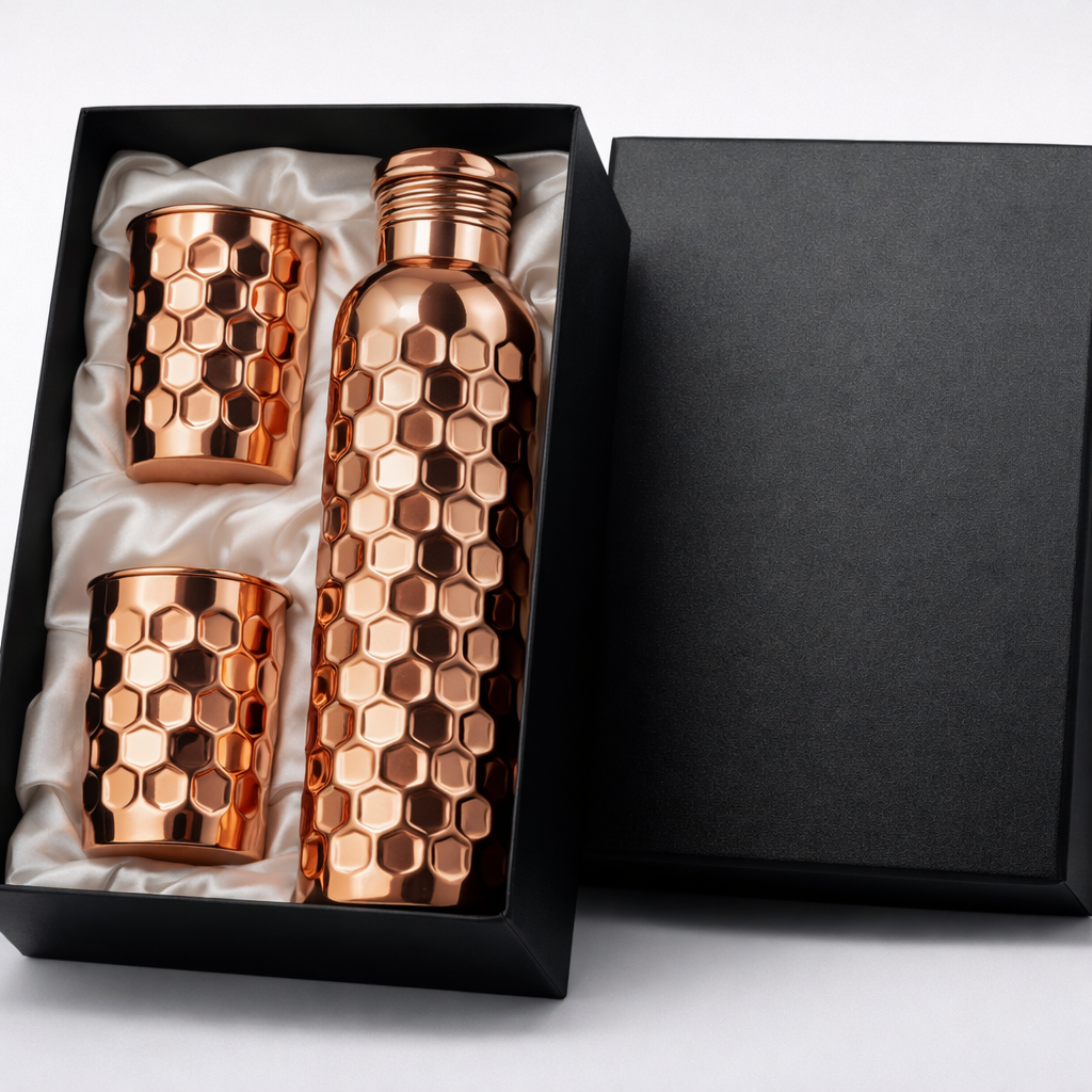 Close-up of a hand-crafted embossed copper bottle and matching glass set